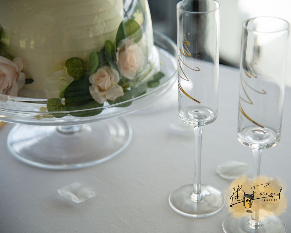 Table setting with wine glasses and floral centerpieces.