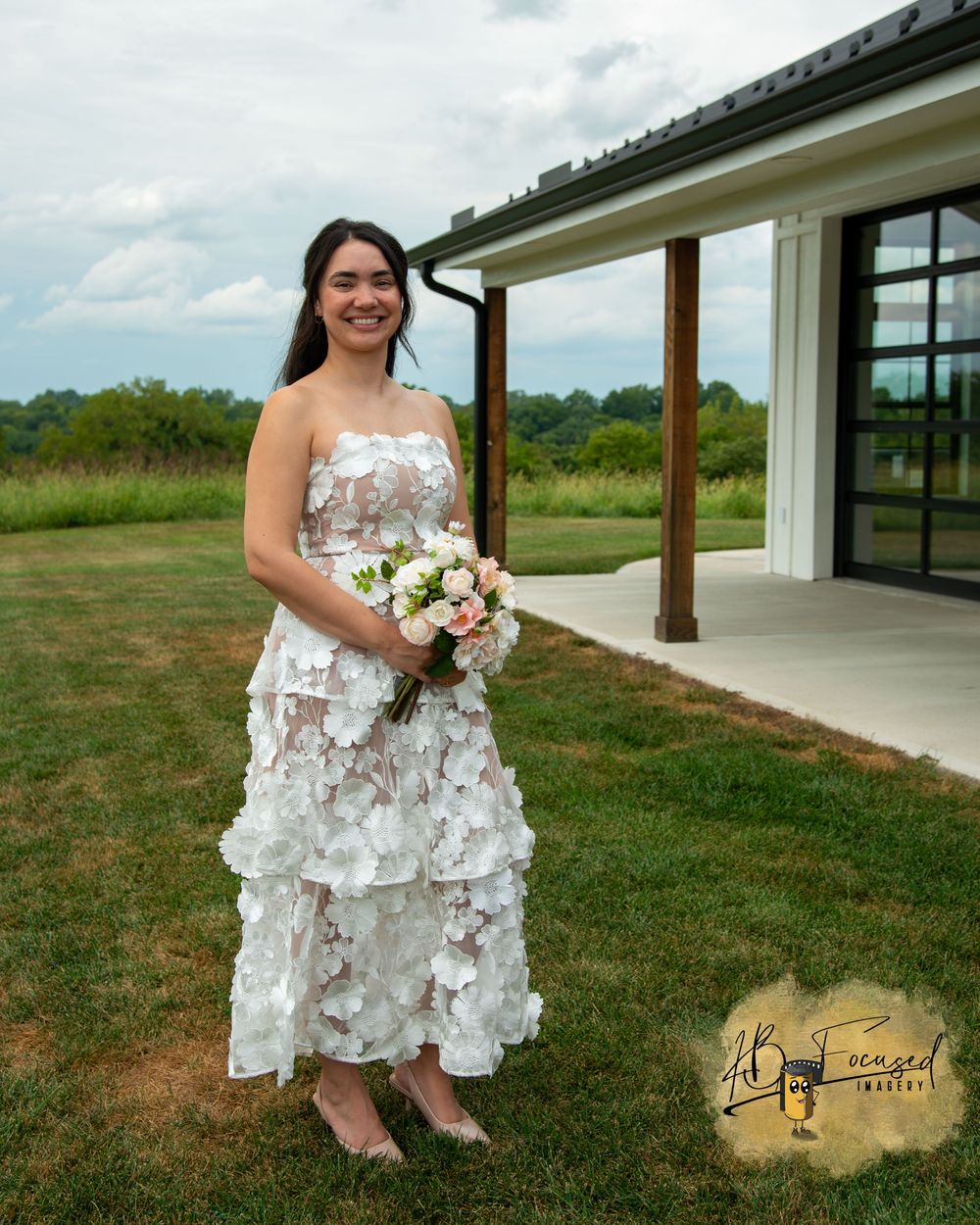 A beautiful white floral dress photographed outdoors near a modern building.