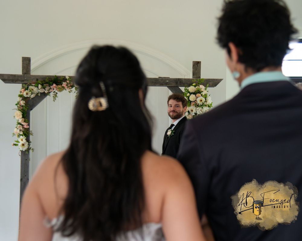 Wedding ceremony venue with white decor and guests.