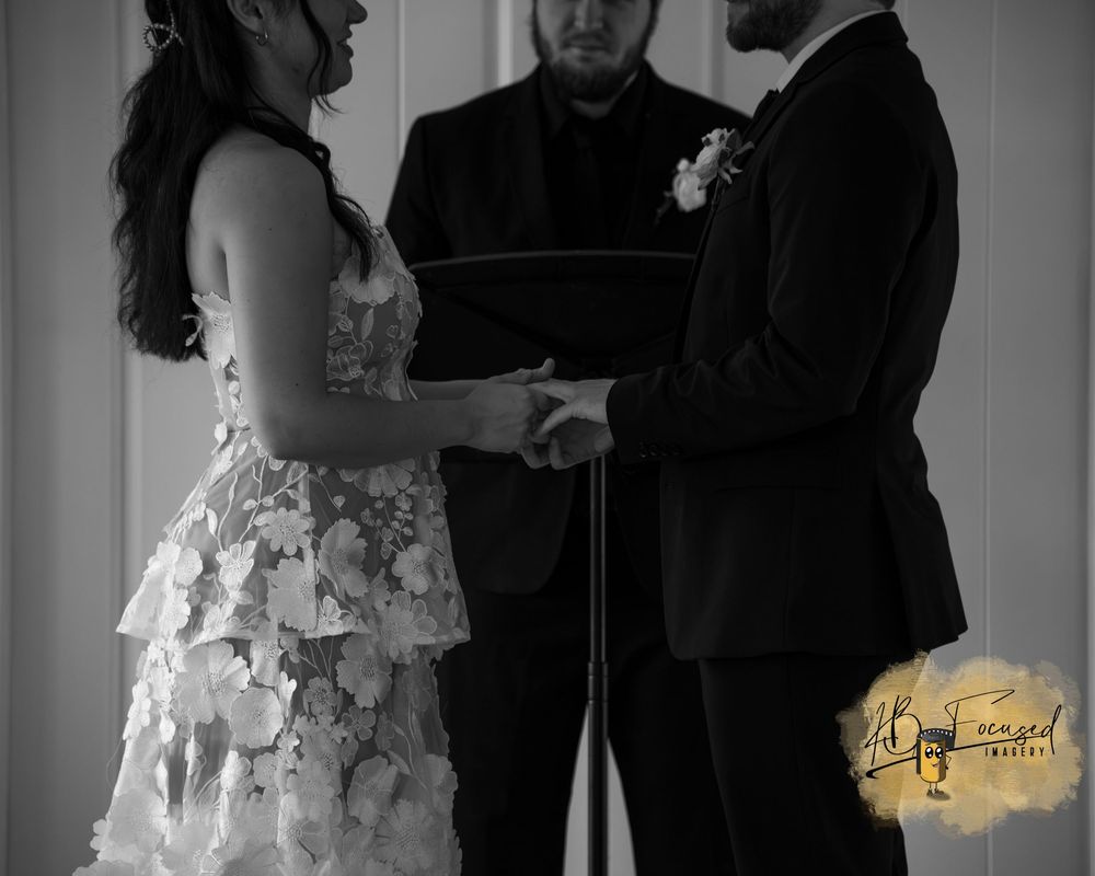 Black and white wedding ceremony scene with formal attire.