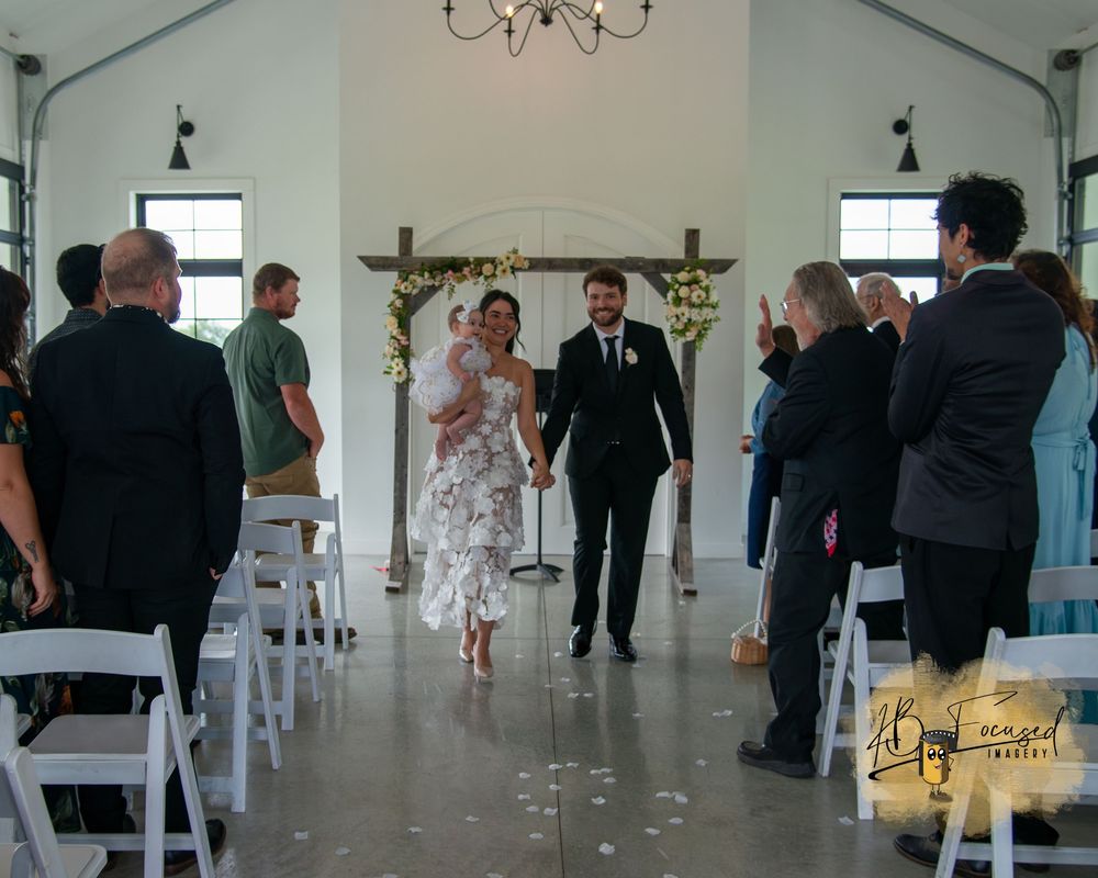 Modern wedding venue interior with chandelier and white decor.