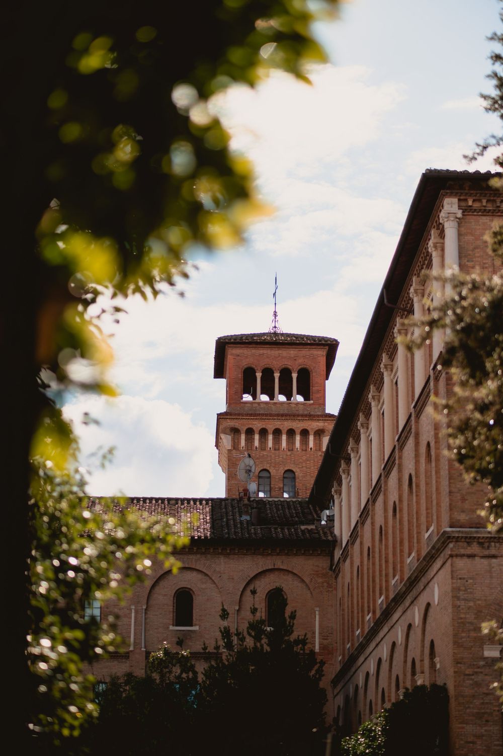 Architectural detail of a historic brick building with towers against a blue sky.