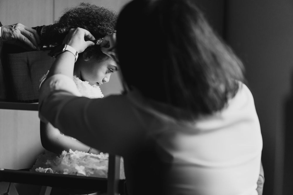 Black and white wedding preparation moments captured in dramatic lighting.