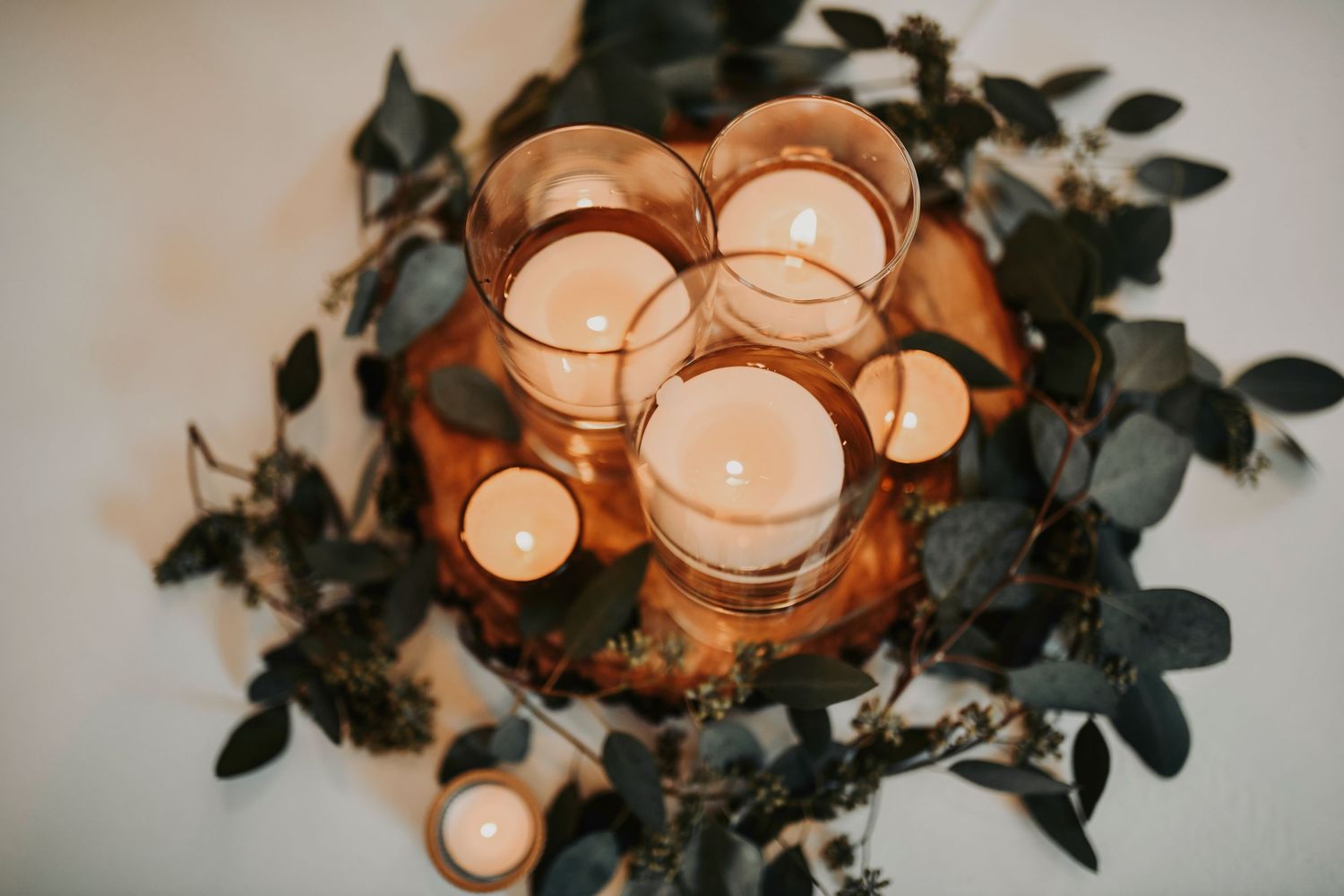 Romantic reception table with glowing candles and greenery at Whispering Oaks Wedding Venue
