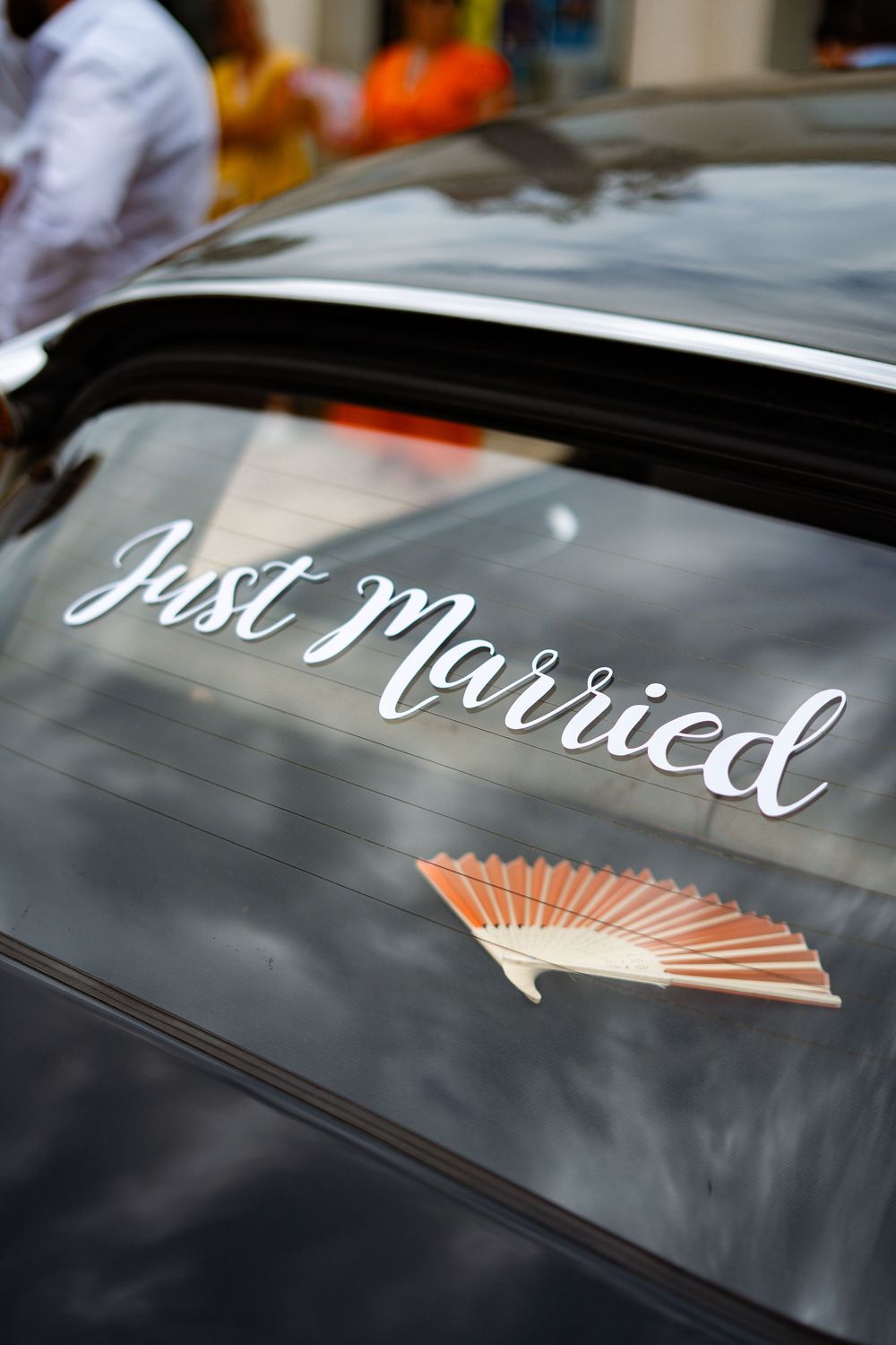 Just married text written in cursive script on a black car window.