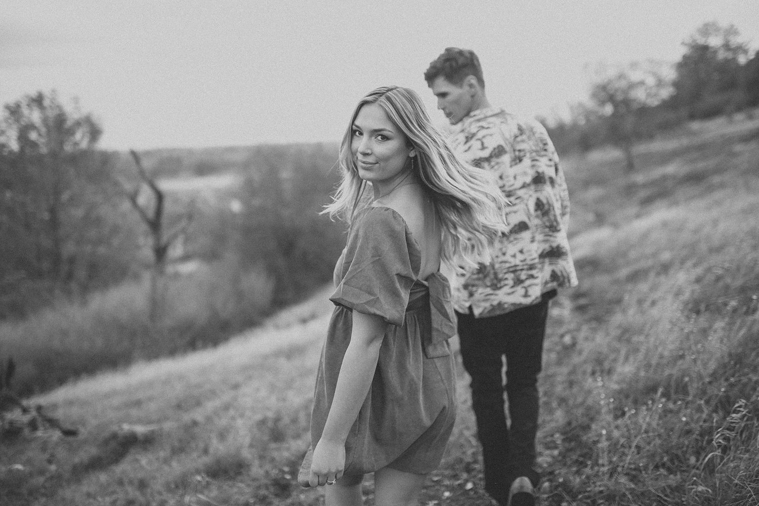 Walking couple during an outdoor engagement session in the California fields
