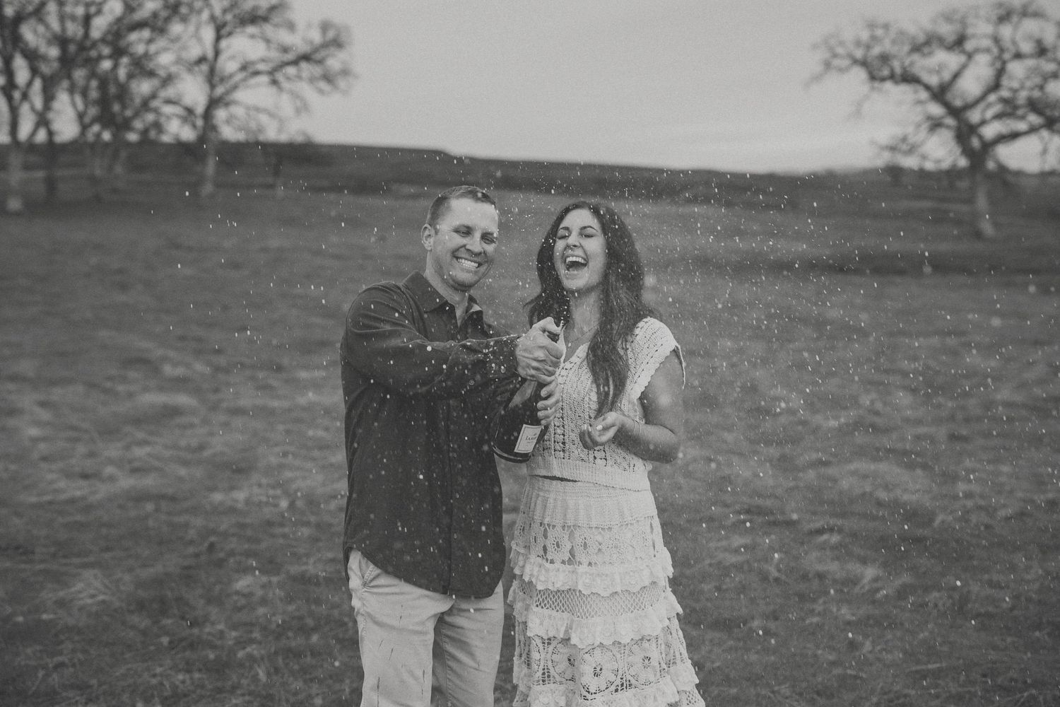 Couple popping champagne in celebration at their North Idaho wedding