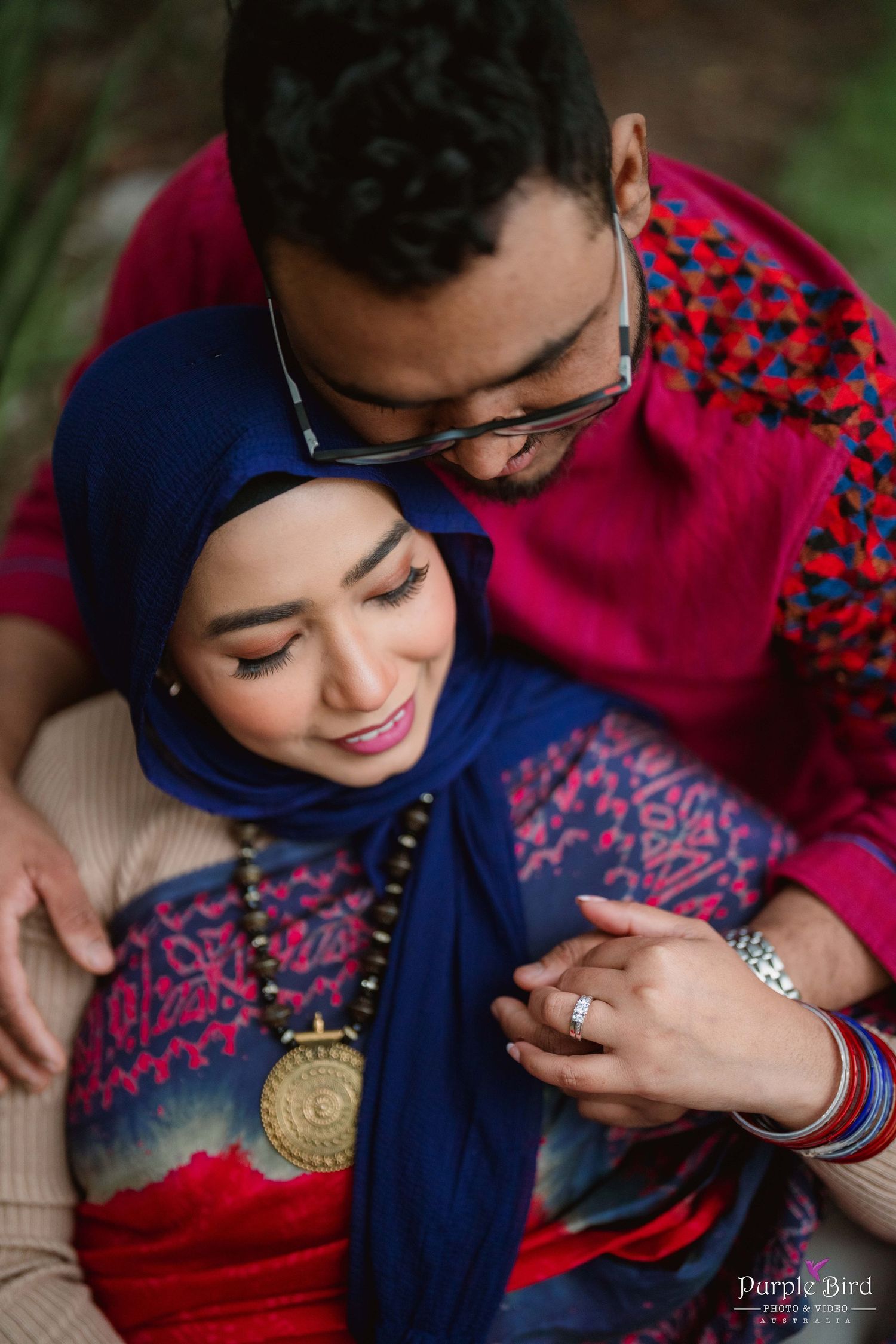 An intimate portrait of a couple in traditional South Asian clothing sharing a tender moment.