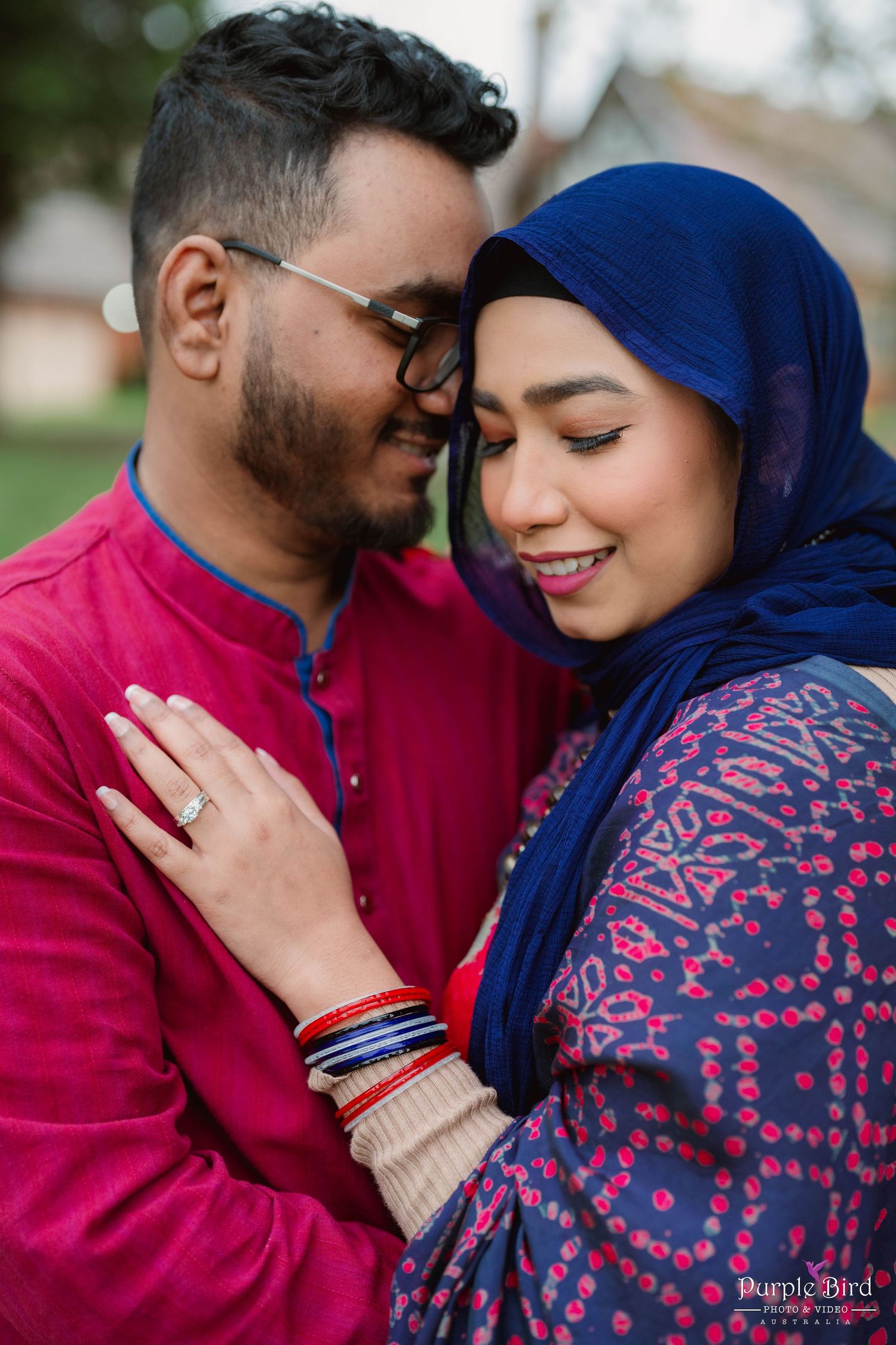 A couple wearing a red sweater and blue headscarf share tender moments in a romantic outdoor photoshoot series.
