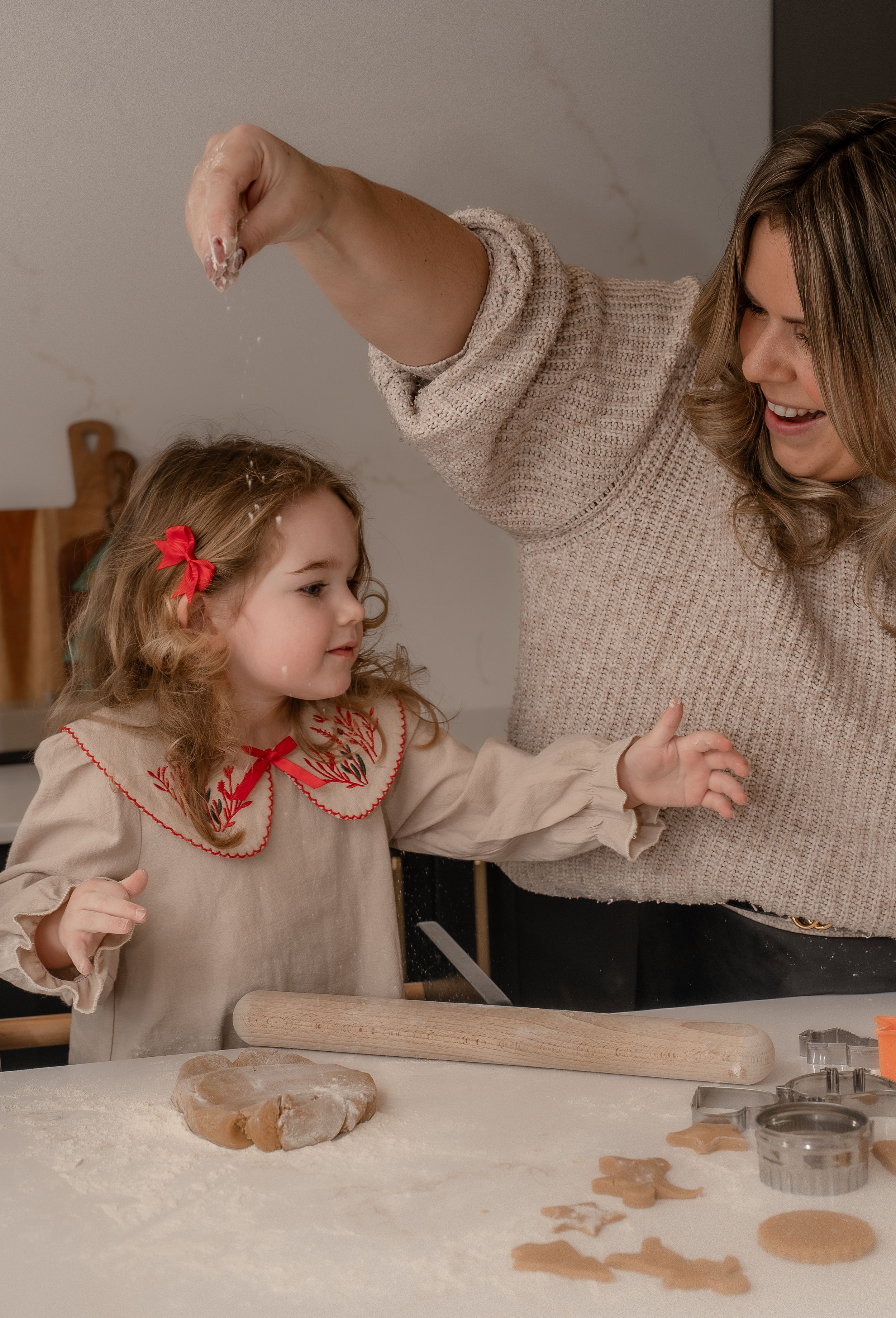 a mum and daughter baking ginger bread cookies with smiles on their faces