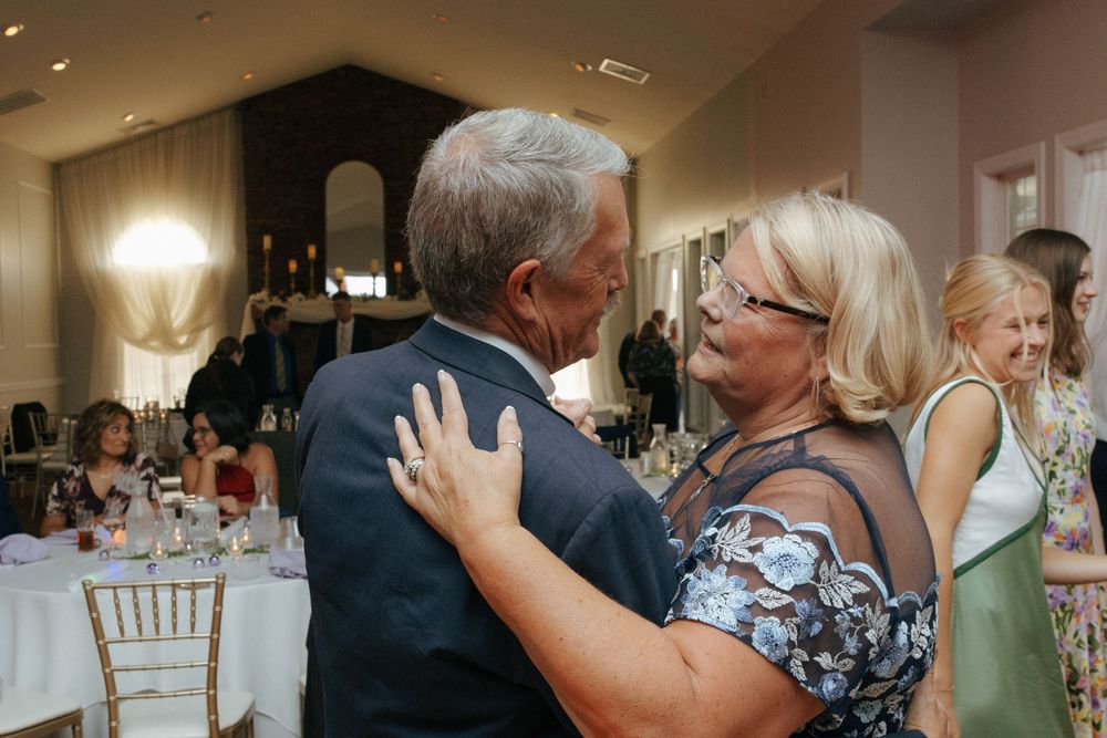 Candid wedding reception with guests on the dance floor having a good time while dancing and celebrating.
