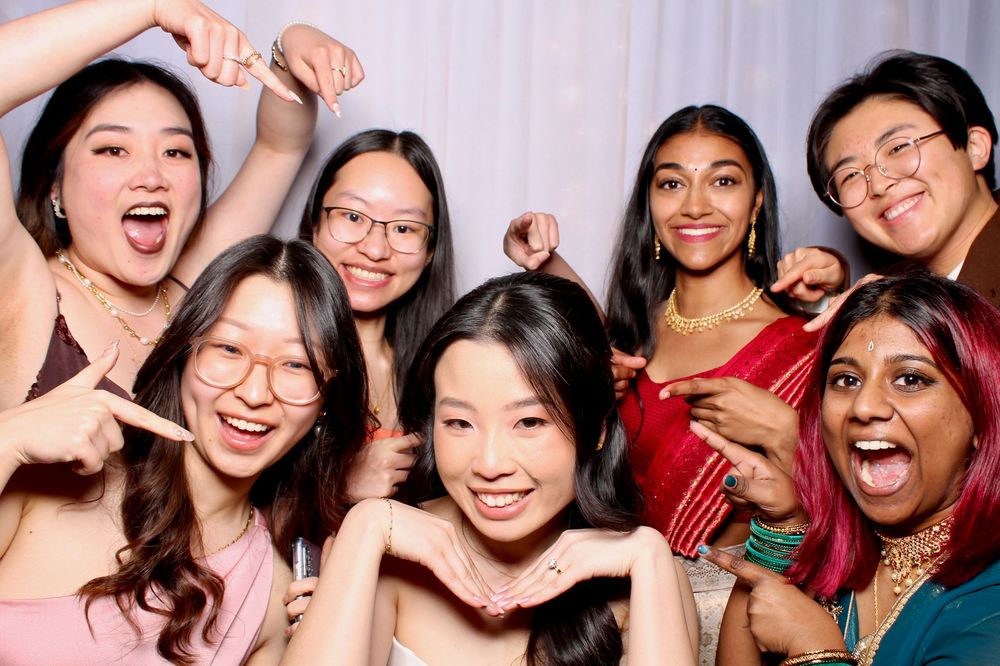 Group of young people smiling and posing together at a celebration while wearing festive attire.