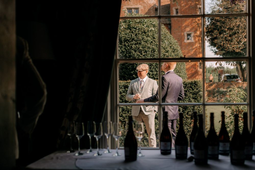 Elegant wedding ceremony set in a charming brick courtyard with natural sunlight filtering through trees.