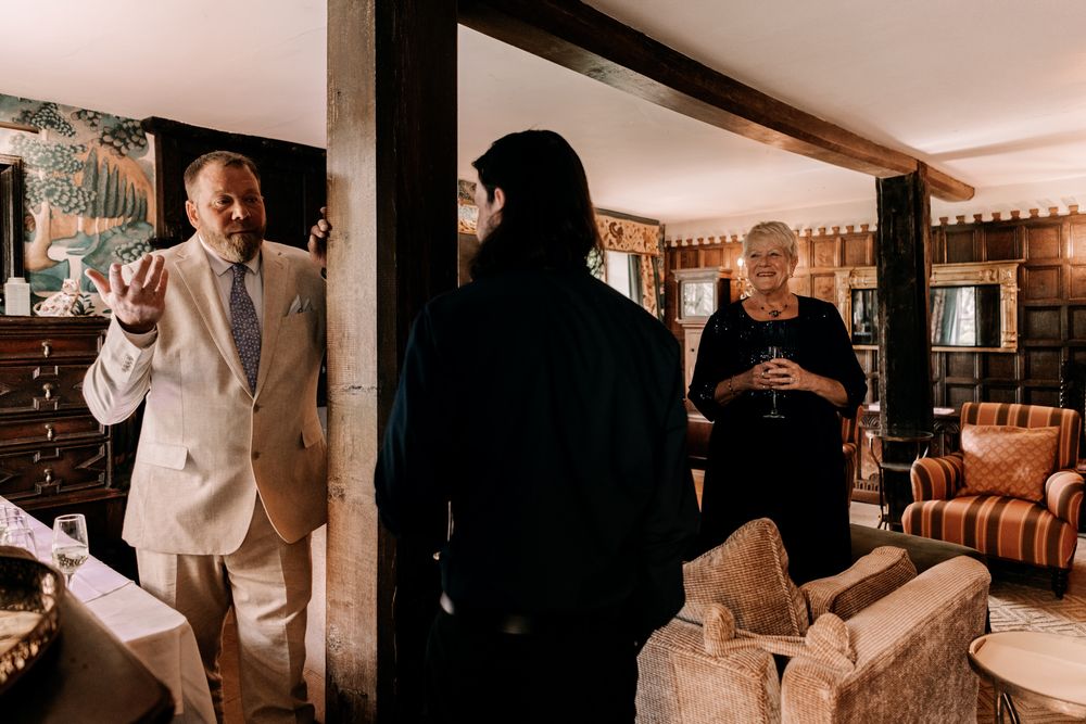 Wine barrels line the walls of a rustic cellar as guests gather and make toasts at a tasting event.