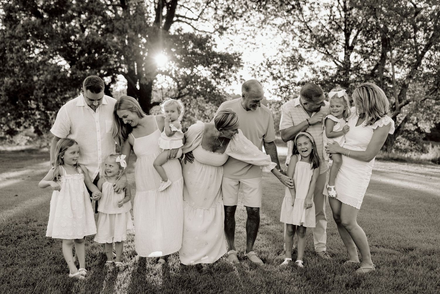 Black and white filmstrip showing family members gathered outdoors in matching outfits for a group photo session.