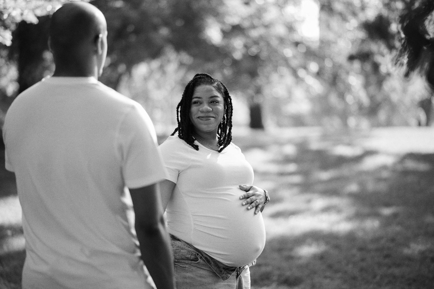 A romantic outdoor photo session captures intimate moments between a couple in a sunlit natural setting.