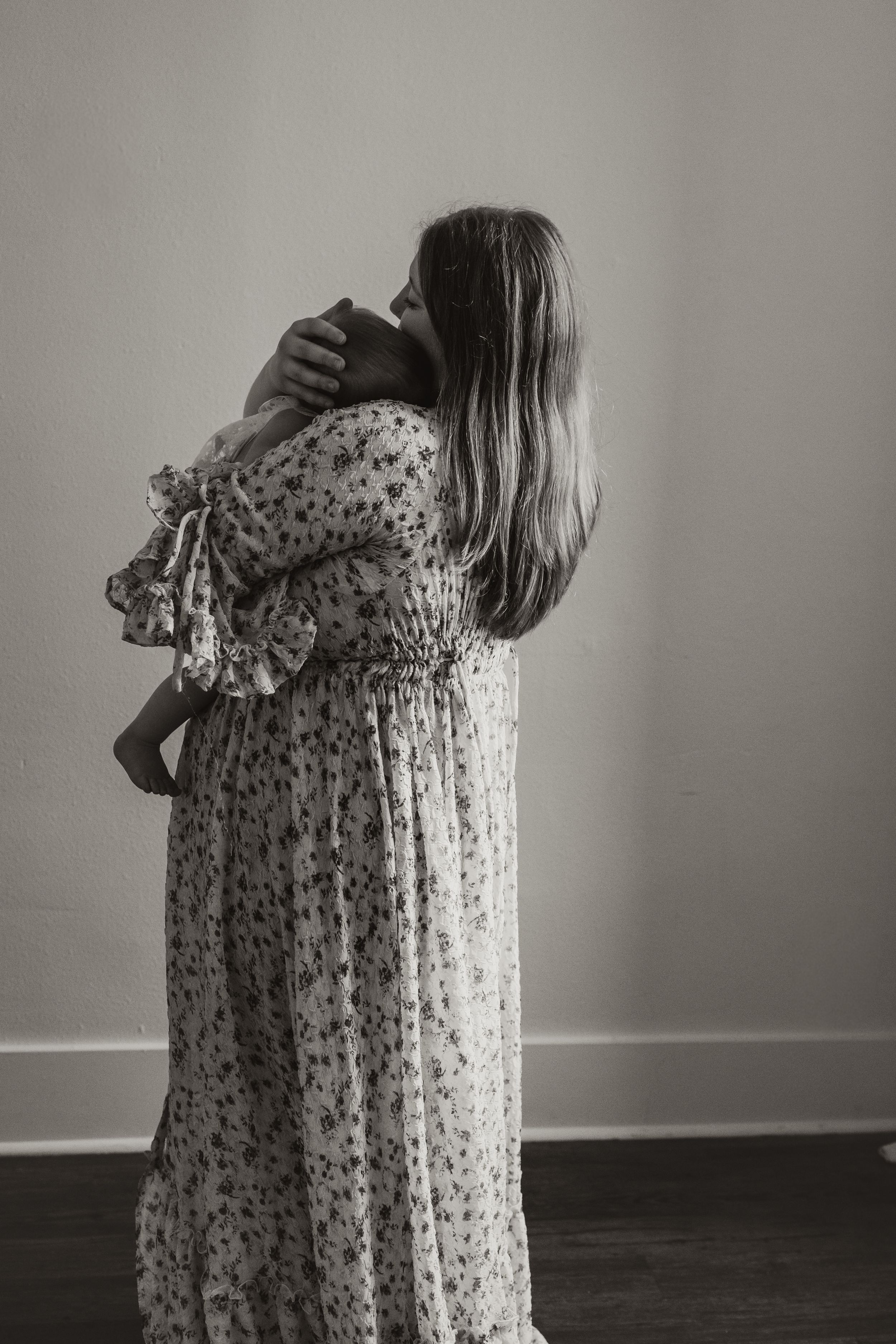 A series of black and white photographs showing a person in a floral dress turning away from the camera.