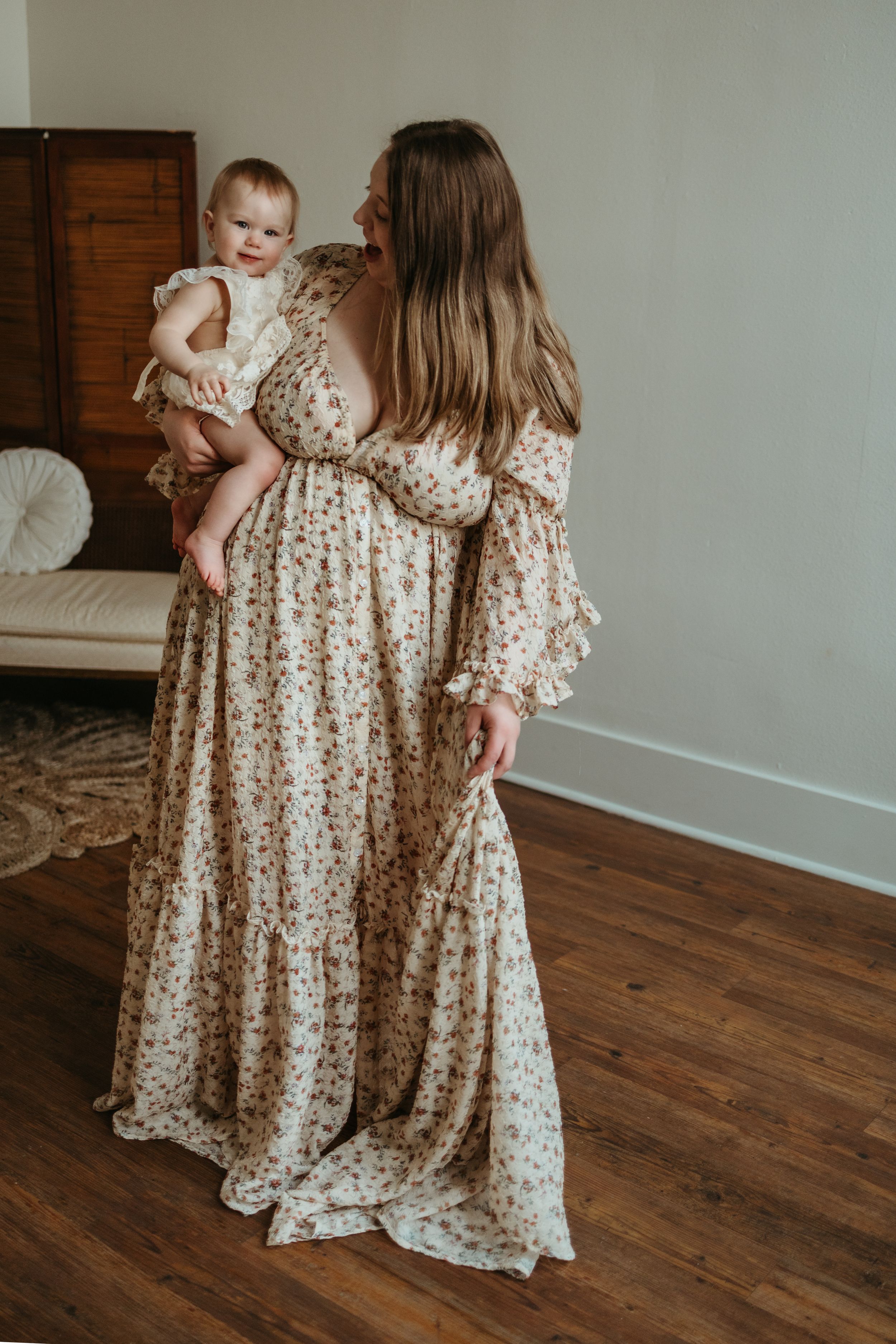 A collection of images showing matching floral dresses on a hardwood floor with white walls in the background.
