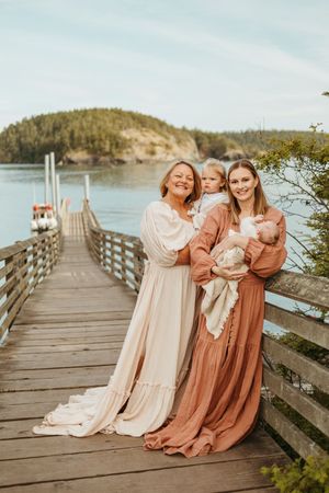 Candid family moments captured on a waterfront boardwalk during golden hour.