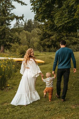 Family walking together through a garden with yellow flowers on a sunny day, shown in a series of connected photos.