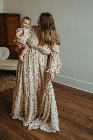 A collection of images showing matching floral dresses on a hardwood floor with white walls in the background.