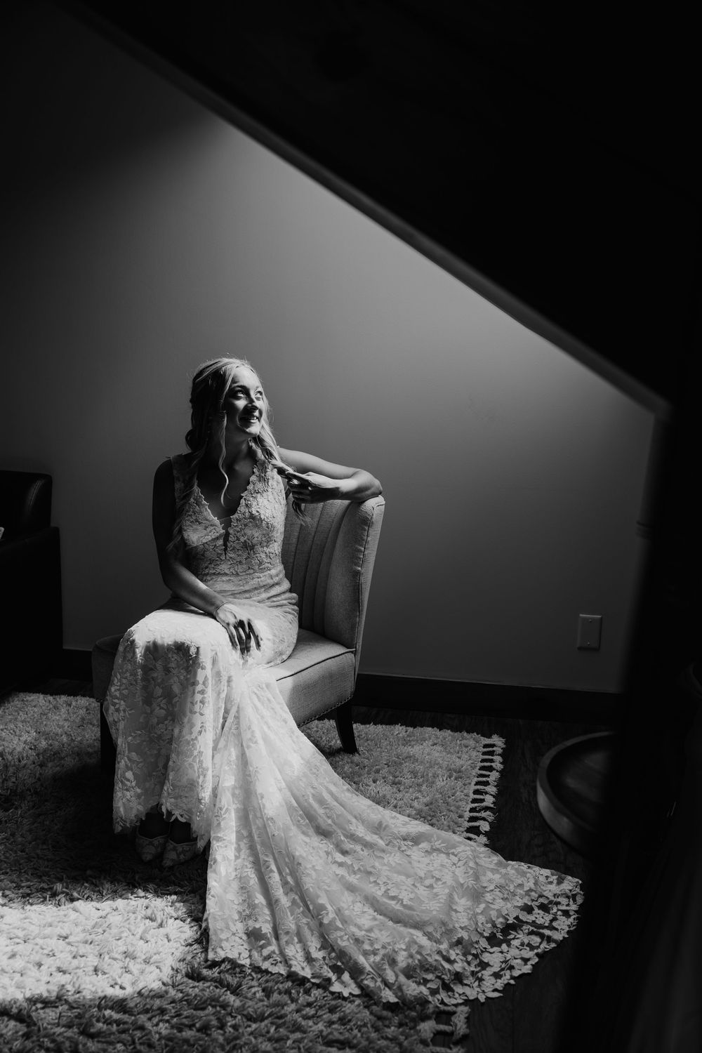 Black and white artistic bridal portraits showing a lace wedding dress with elegant train in dramatic lighting.