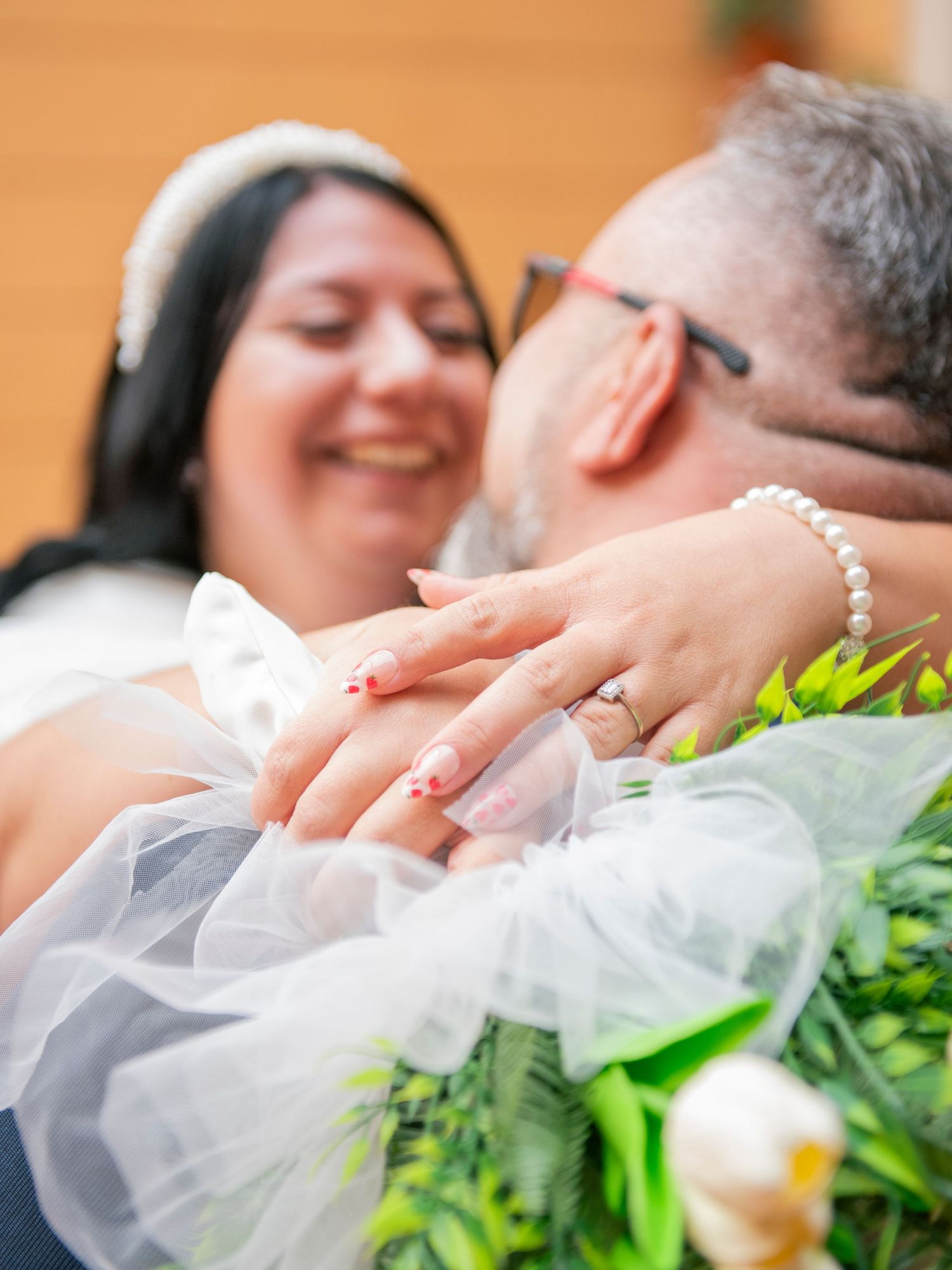 A couple shares a romantic kiss while holding a bouquet of flowers during their wedding ceremony.