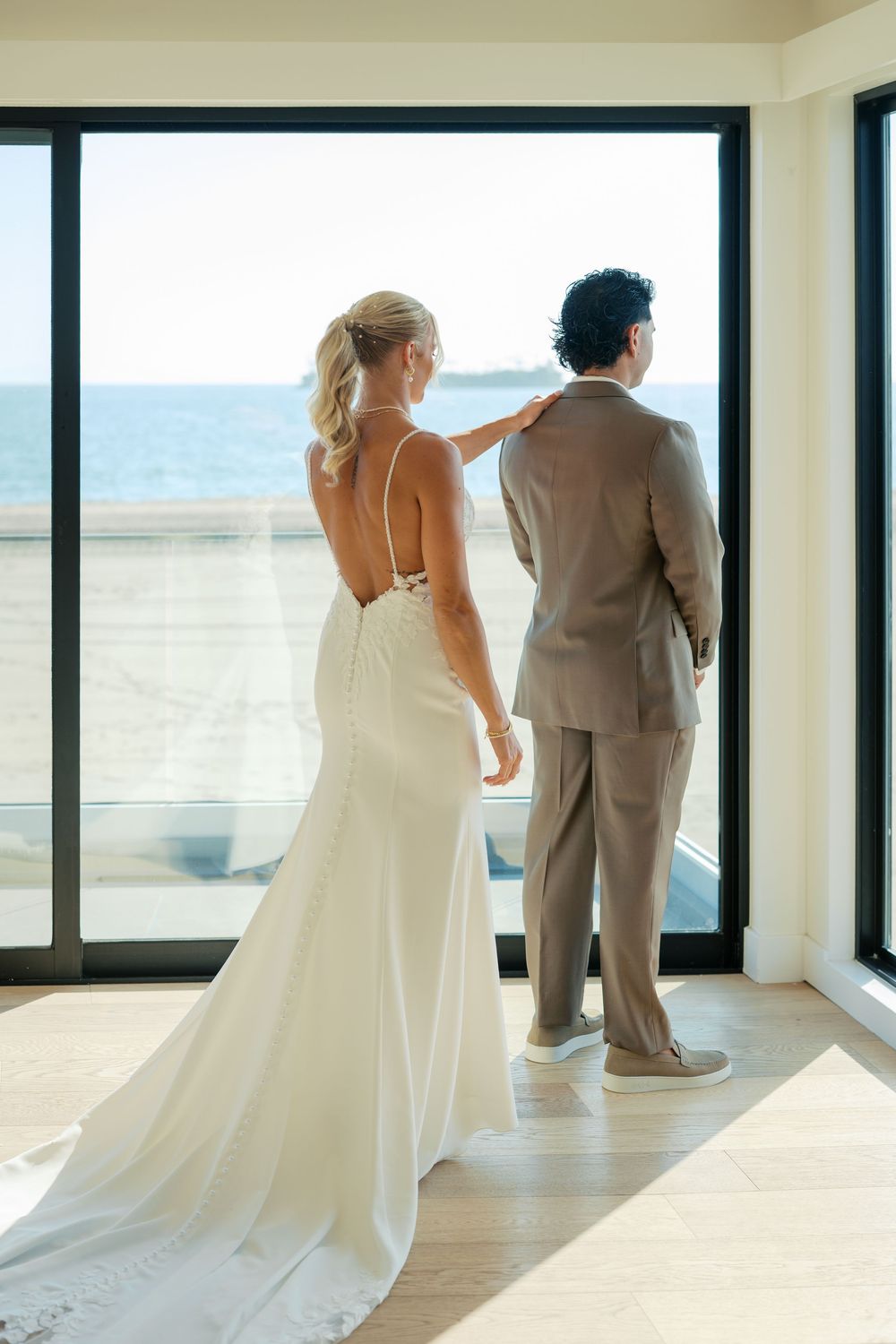 Series of wedding photos showing a couple in a bright white room with large windows overlooking scenic outdoor views.