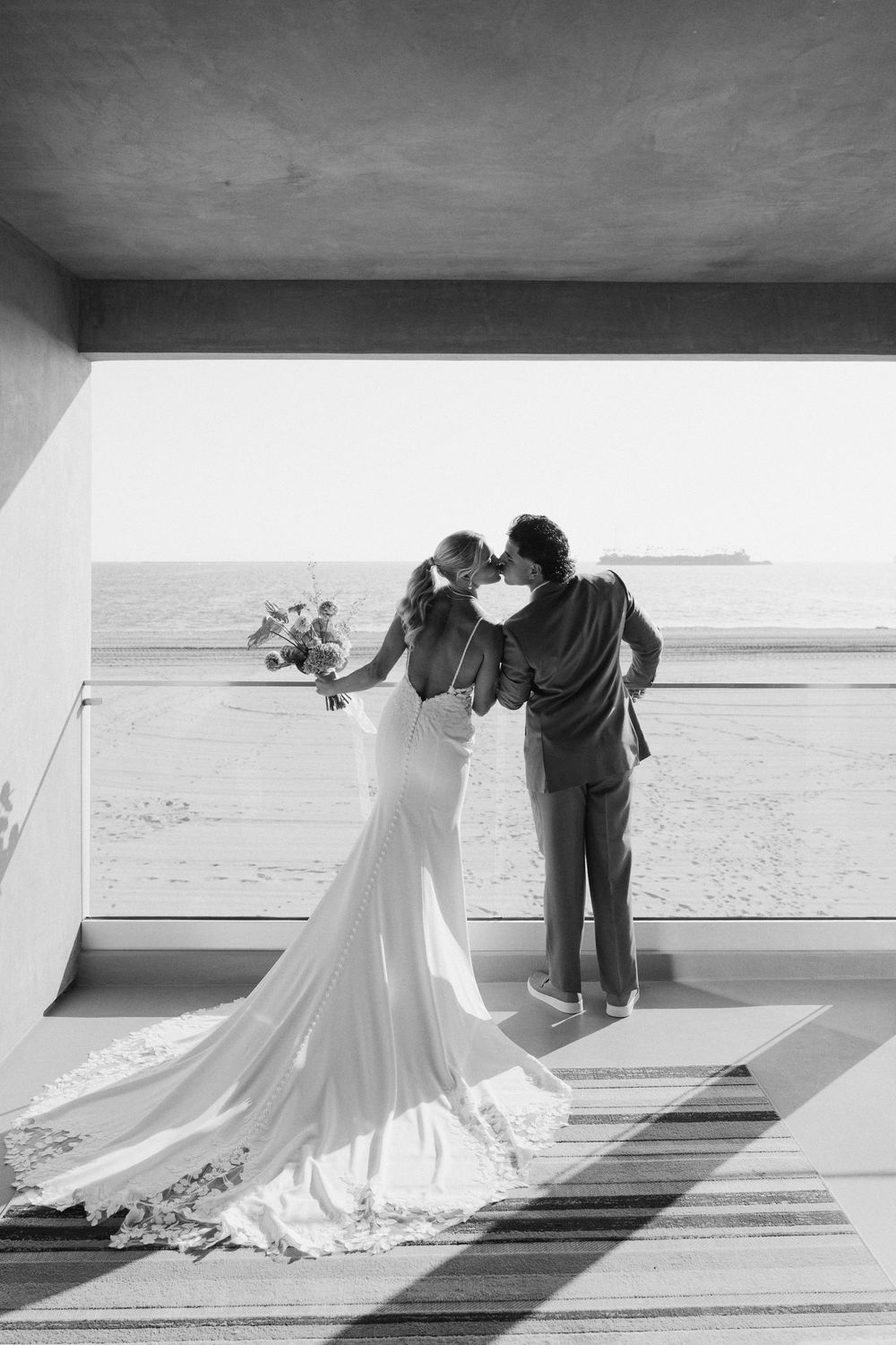 A series of dreamy wedding photos showing a couple dancing on a bright beach boardwalk in elegant attire.