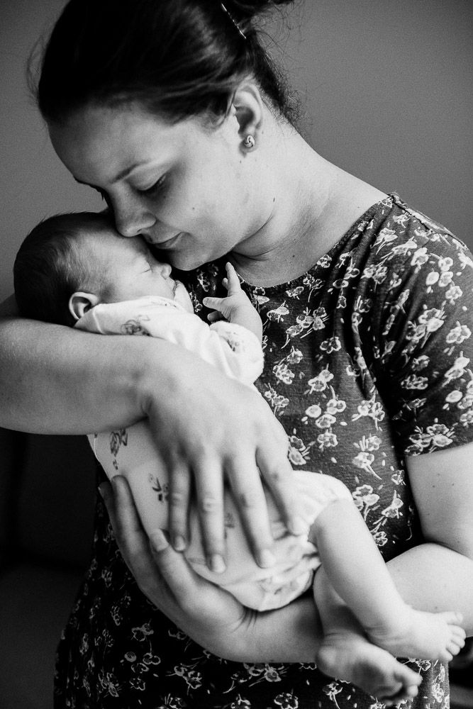 Black and white portrait series showing tender moments with sleeping newborn.