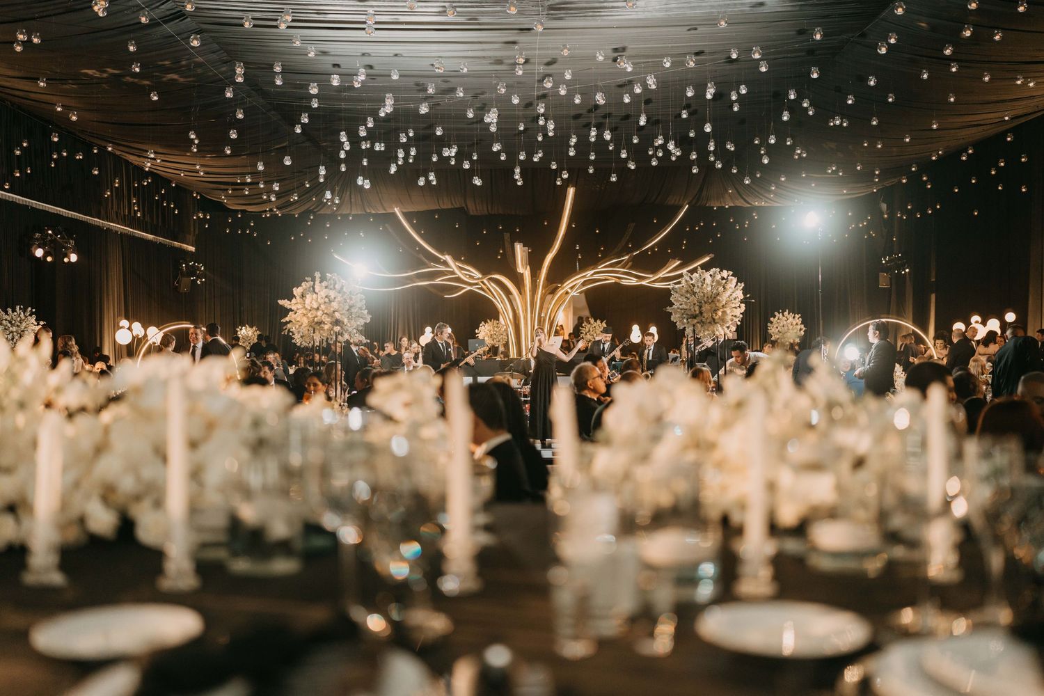 Romantic wedding reception space with twinkling string lights creating a starry night effect.