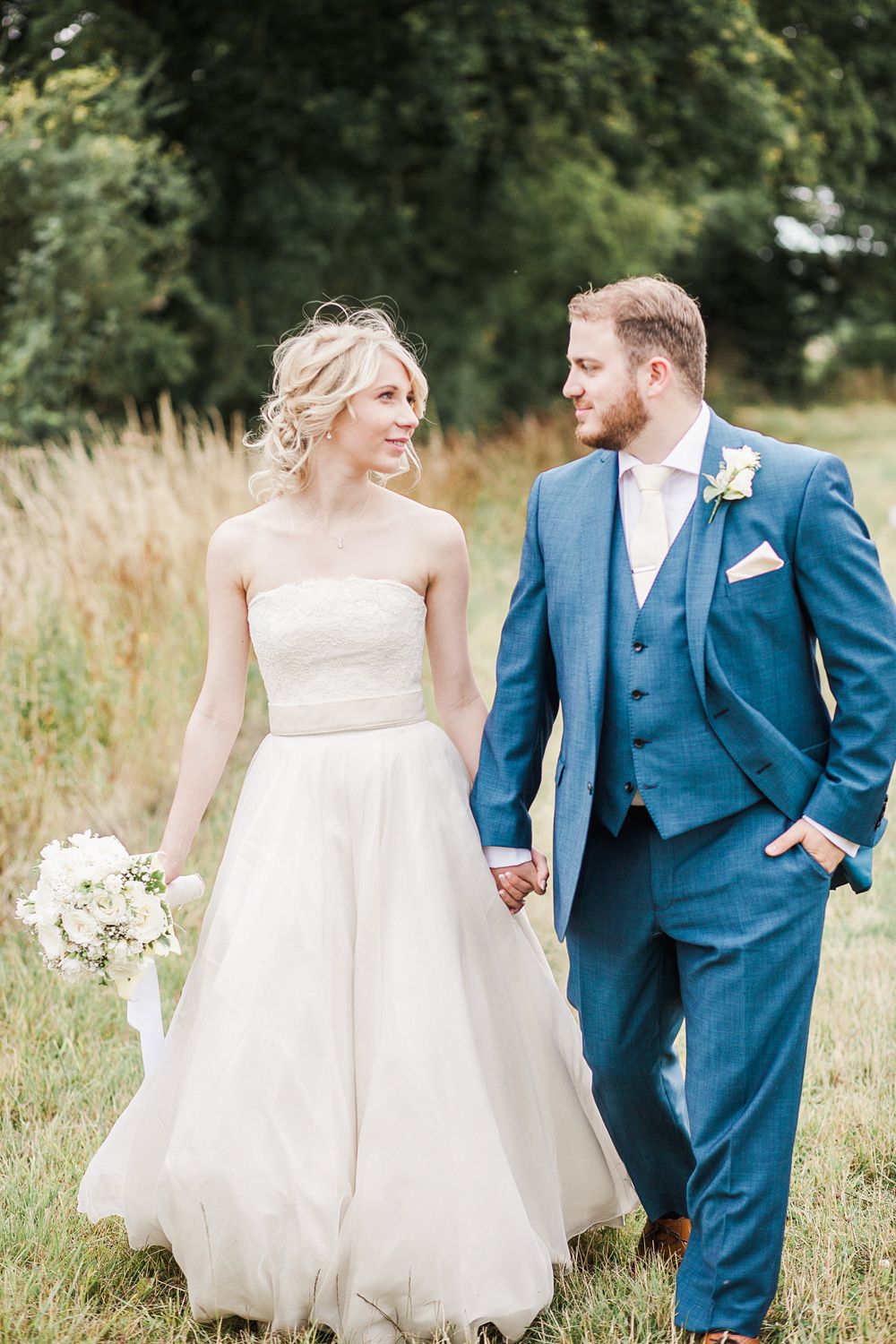 Wedding couple photographed against stone wall covered in red and green ivy.
