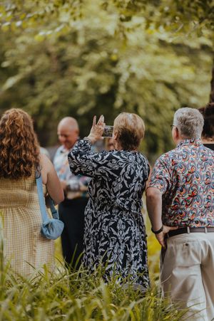 Wedding guests in patterned attire standing together at an outdoor reception.