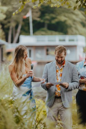 Wedding guests in formal attire mingling at an outdoor garden reception.