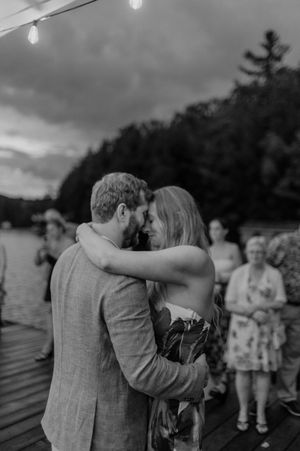 A romantic embrace during a lakeside celebration at dusk.