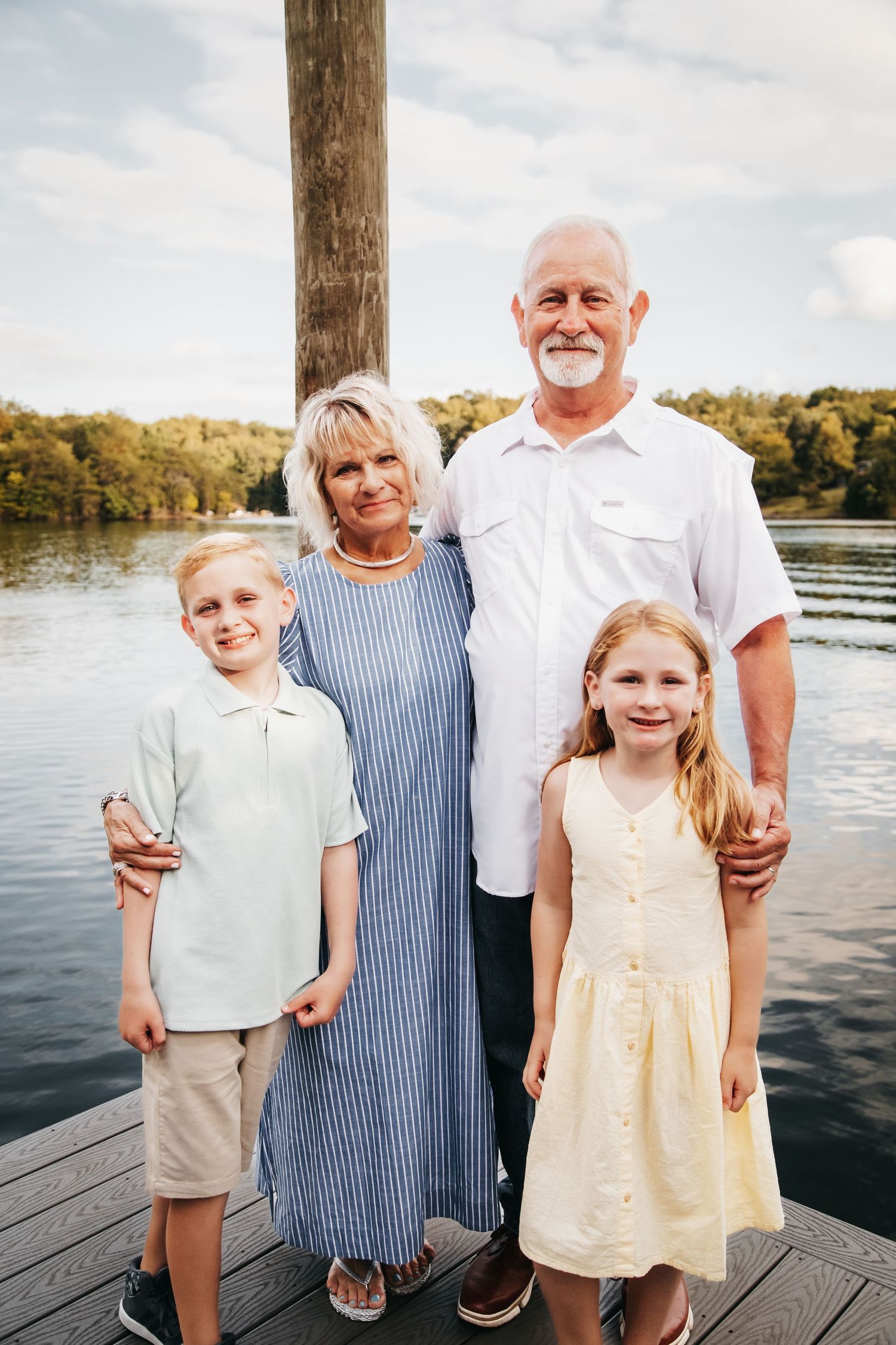 Grandparents with their grandson and granddaughter with the lake in the background.