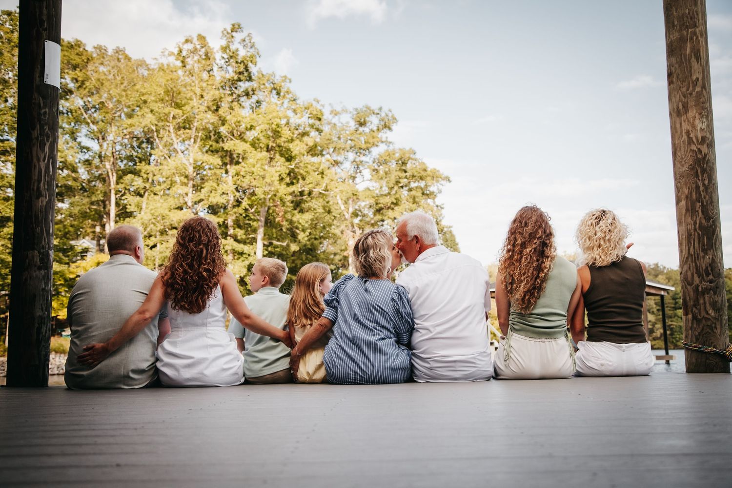 Smith Mountain Lake family sitting on the dock facing the lake.