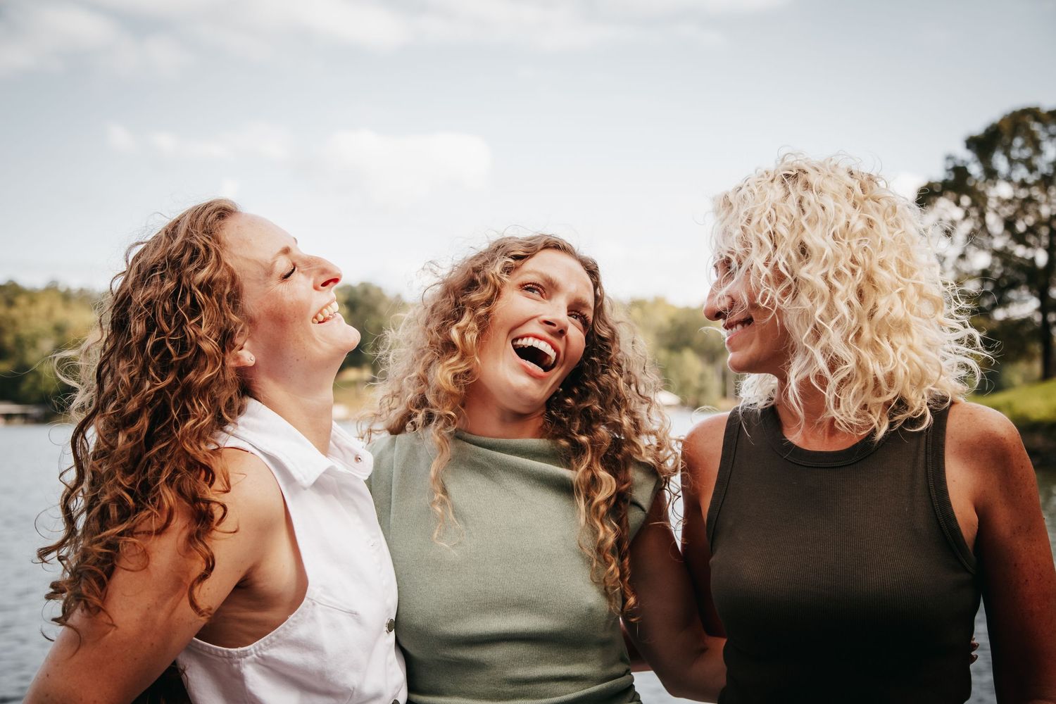 Three sisters laughing and embracing.