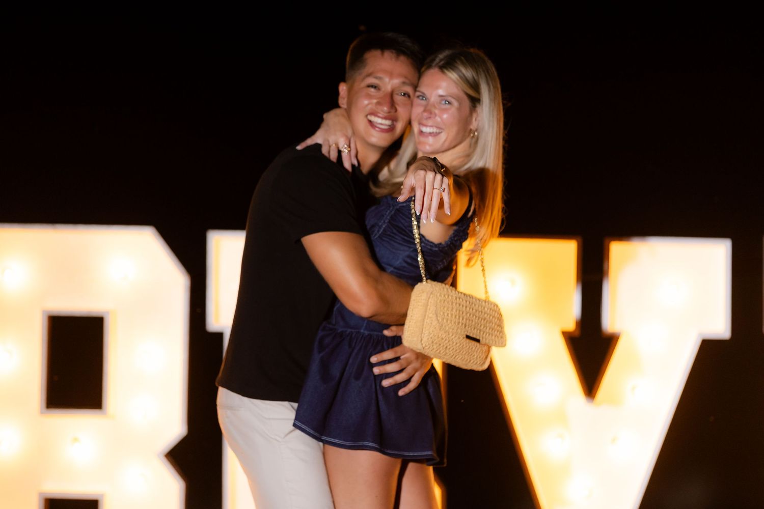 A seaside marriage proposal scene with glowing letters and rose petals creating a romantic atmosphere.