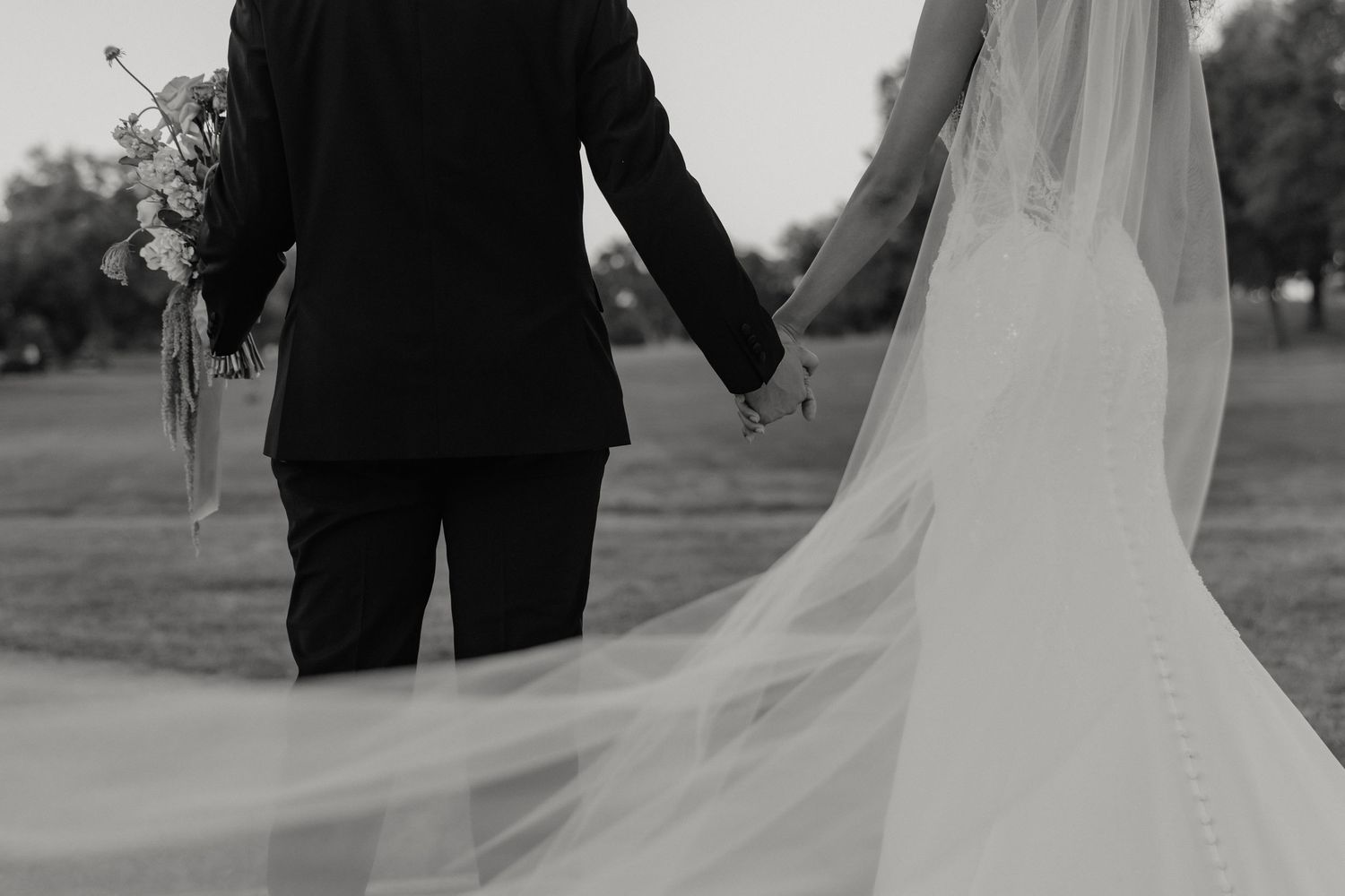 Black and white detail shot of a bride and groom sitting together showing dress and suit during golden hour for Sacramento wedding