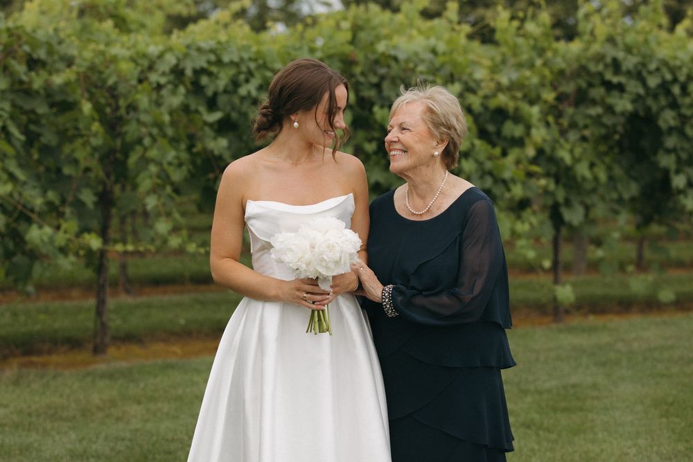 Tender moments shared between wedding party members in outdoor garden setting.