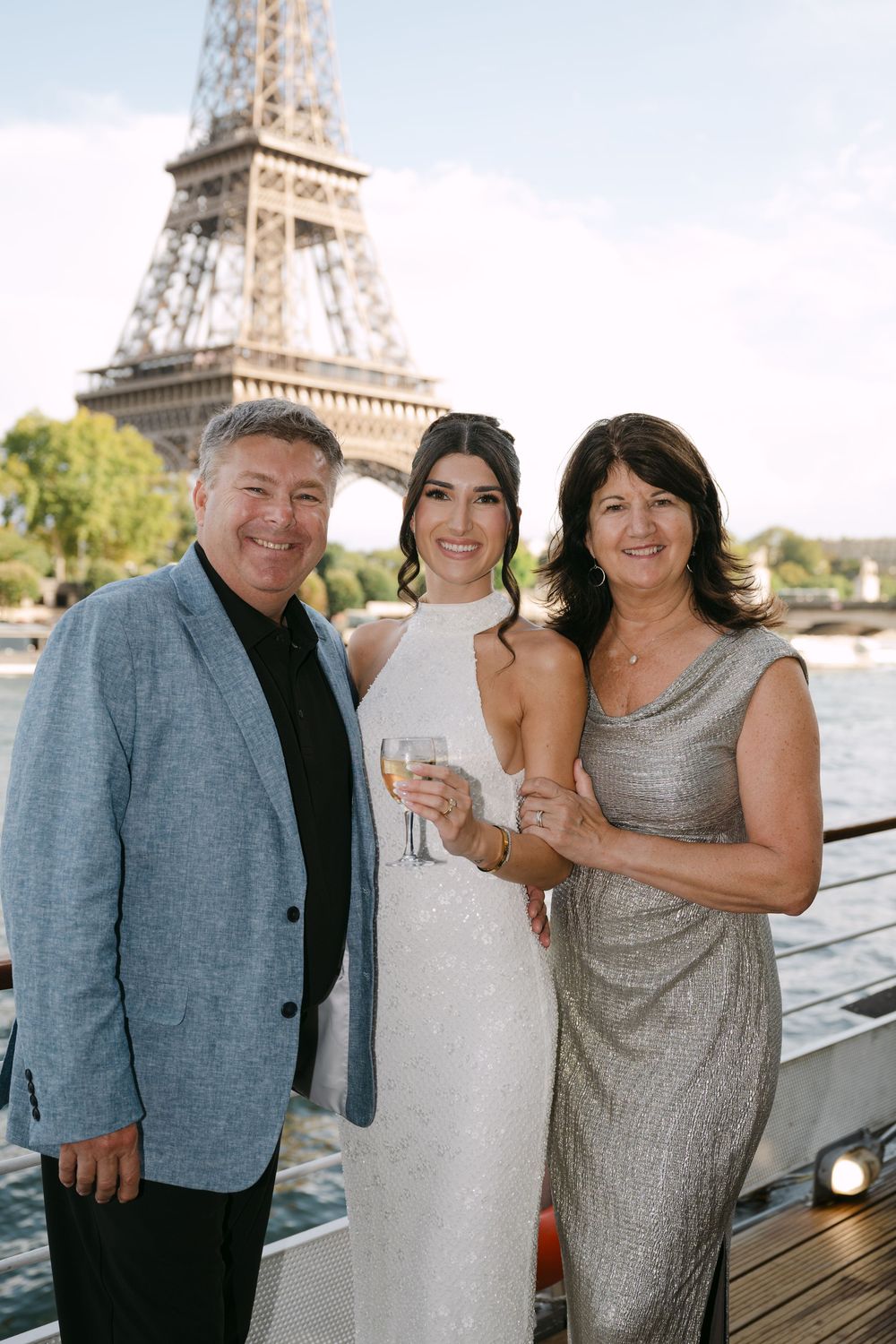 Guests pose on a terrace with the Eiffel Tower in the background during a celebration in Paris.