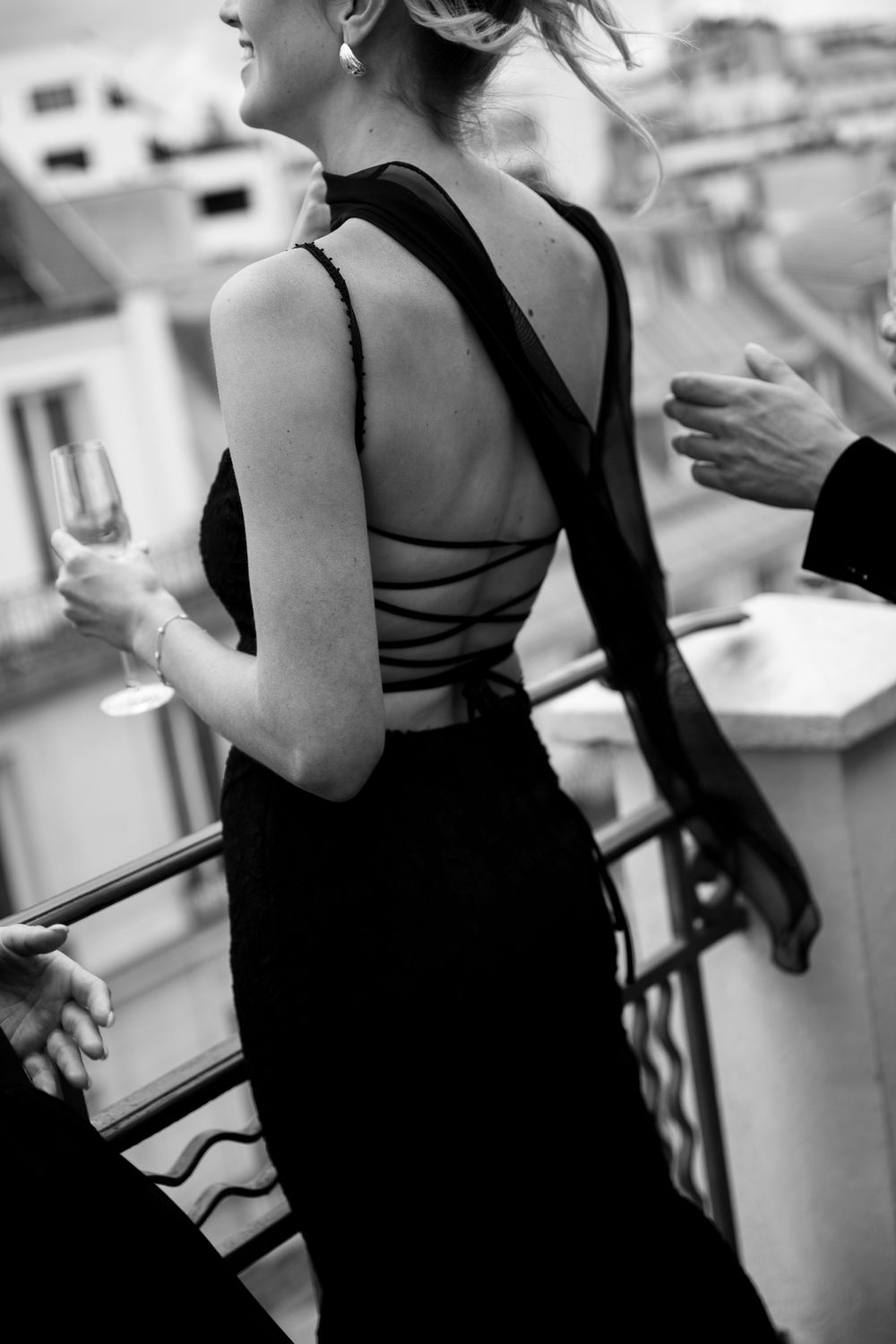 People in elegant black attire socializing at an upscale event.