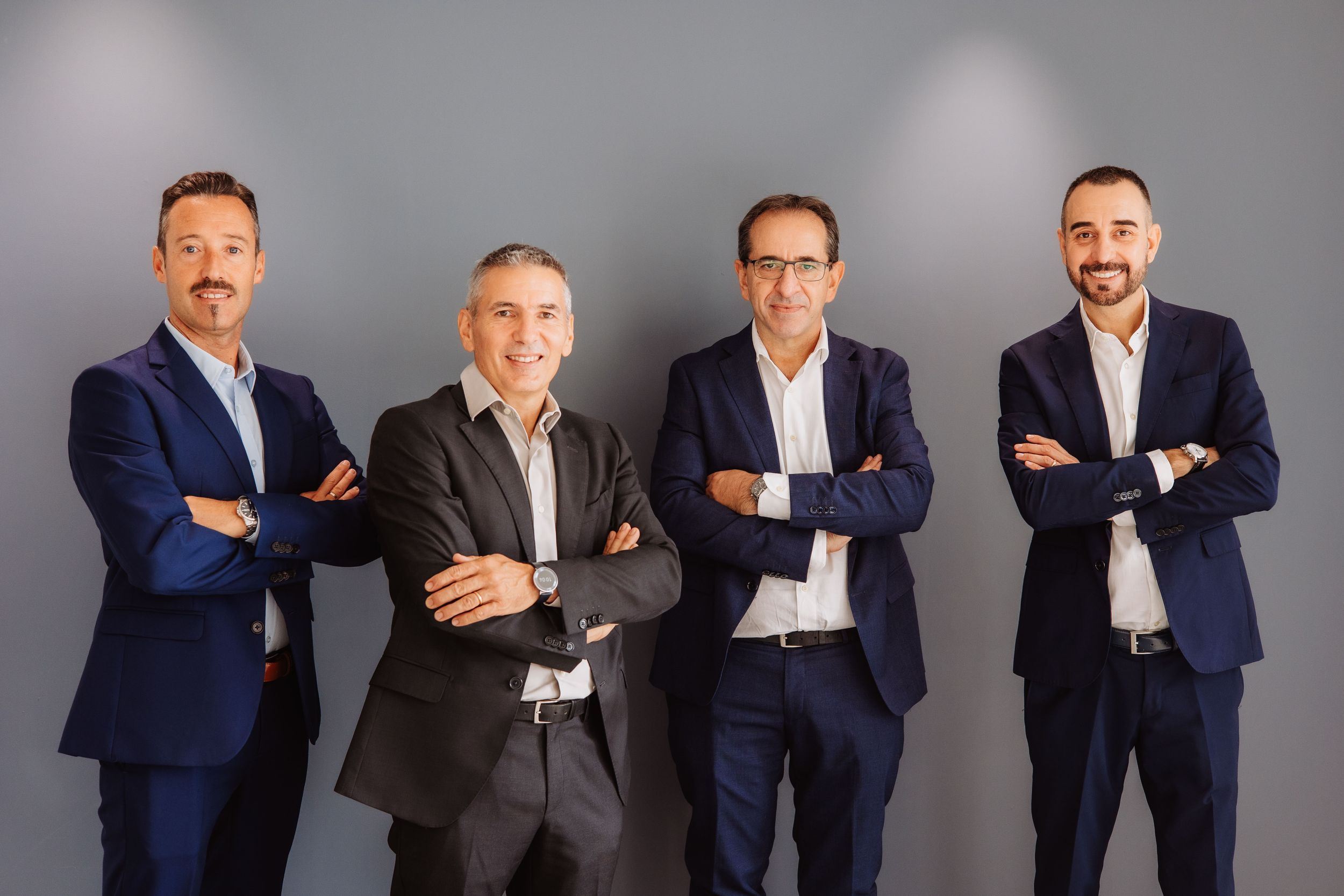 A sequence of business professionals in navy suits standing in relaxed poses against a gray background.