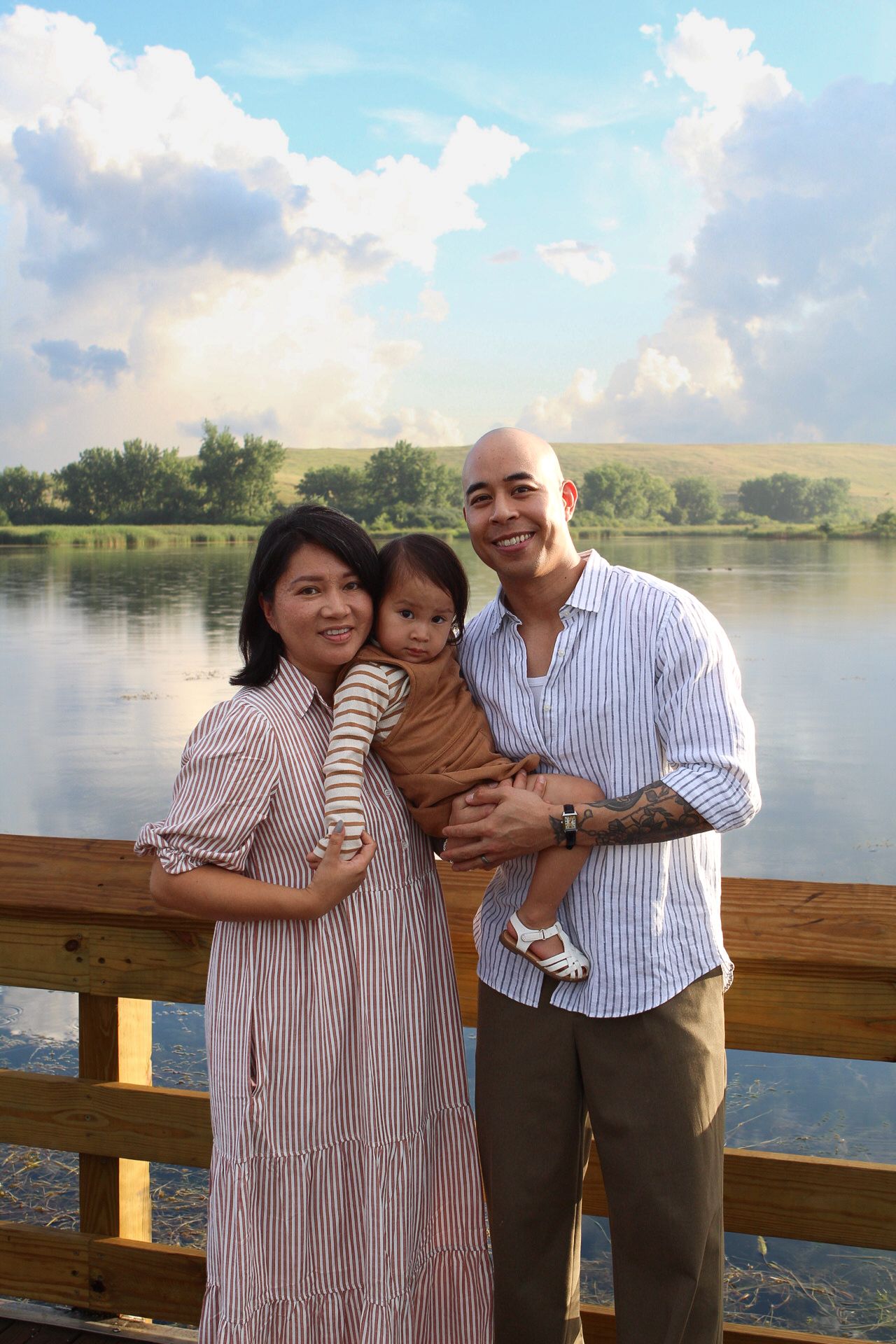 Family enjoying time together on wooden dock by peaceful lake.