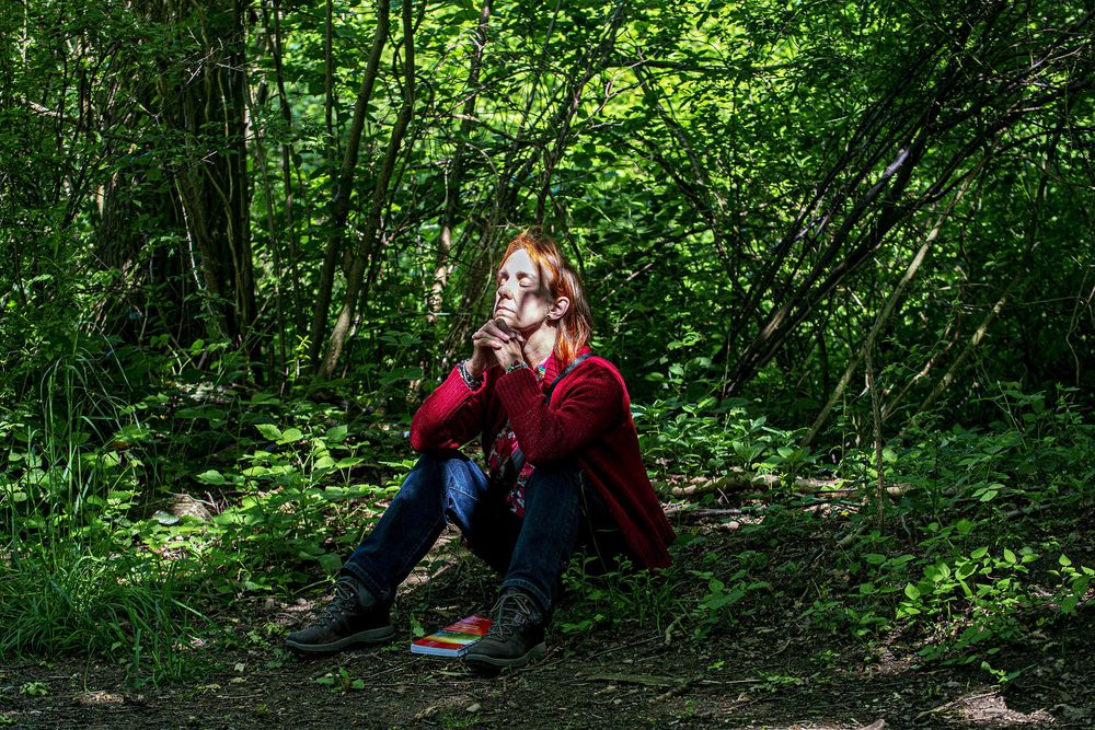 Woodland Well-being portrait for the Suffolk Wildlife Trust - A woman resting in a sunlit woodland, Suffolk