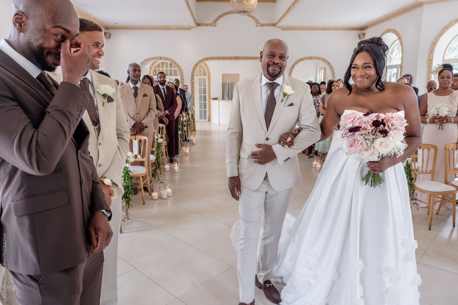 Wedding party gathered in a beautiful white chapel with elegant architecture and natural lighting.
