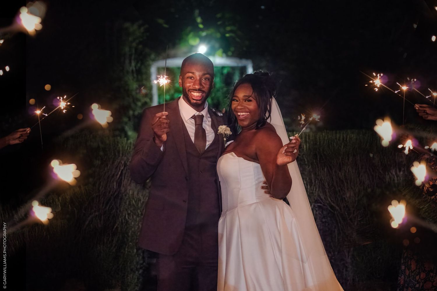 Wedding couple shares a joyful dance together during their evening outdoor reception celebration.
