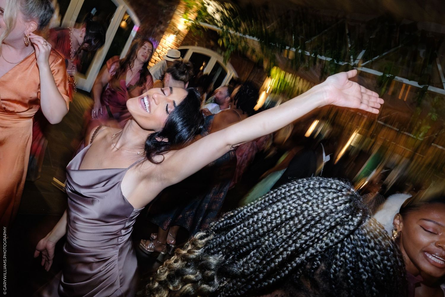 A group of people dancing and enjoying themselves at a lively nighttime party or celebration.