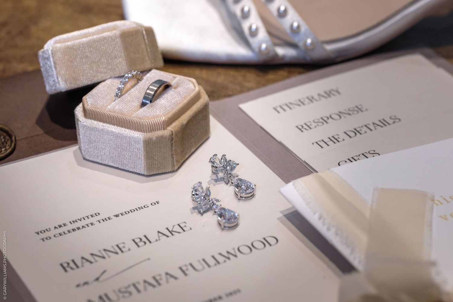Wedding rings and paper details arranged artistically on a rustic wooden surface for a romantic celebration.